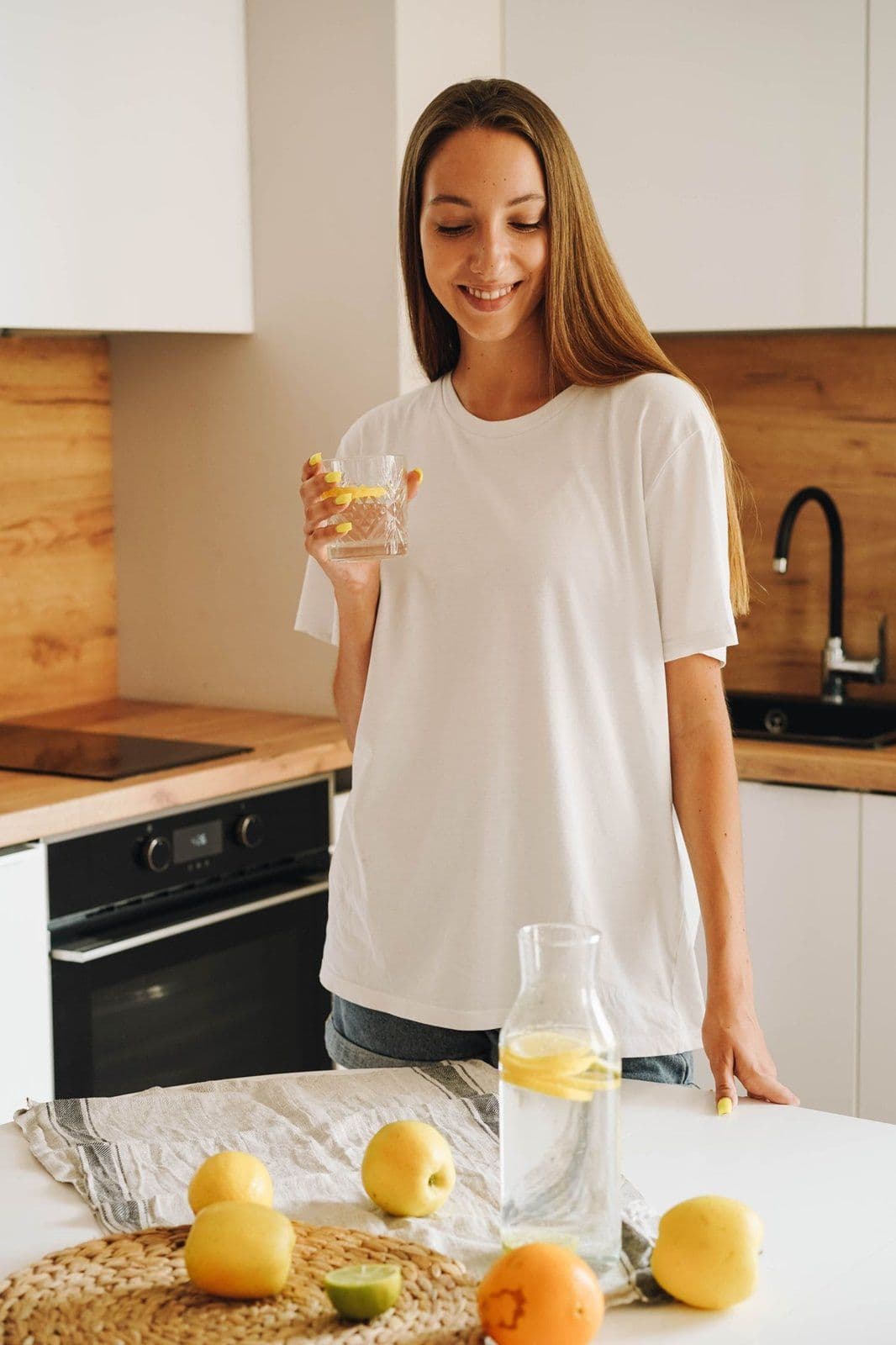 Personne souriante avec une boisson sans alcool (eau citronnée)